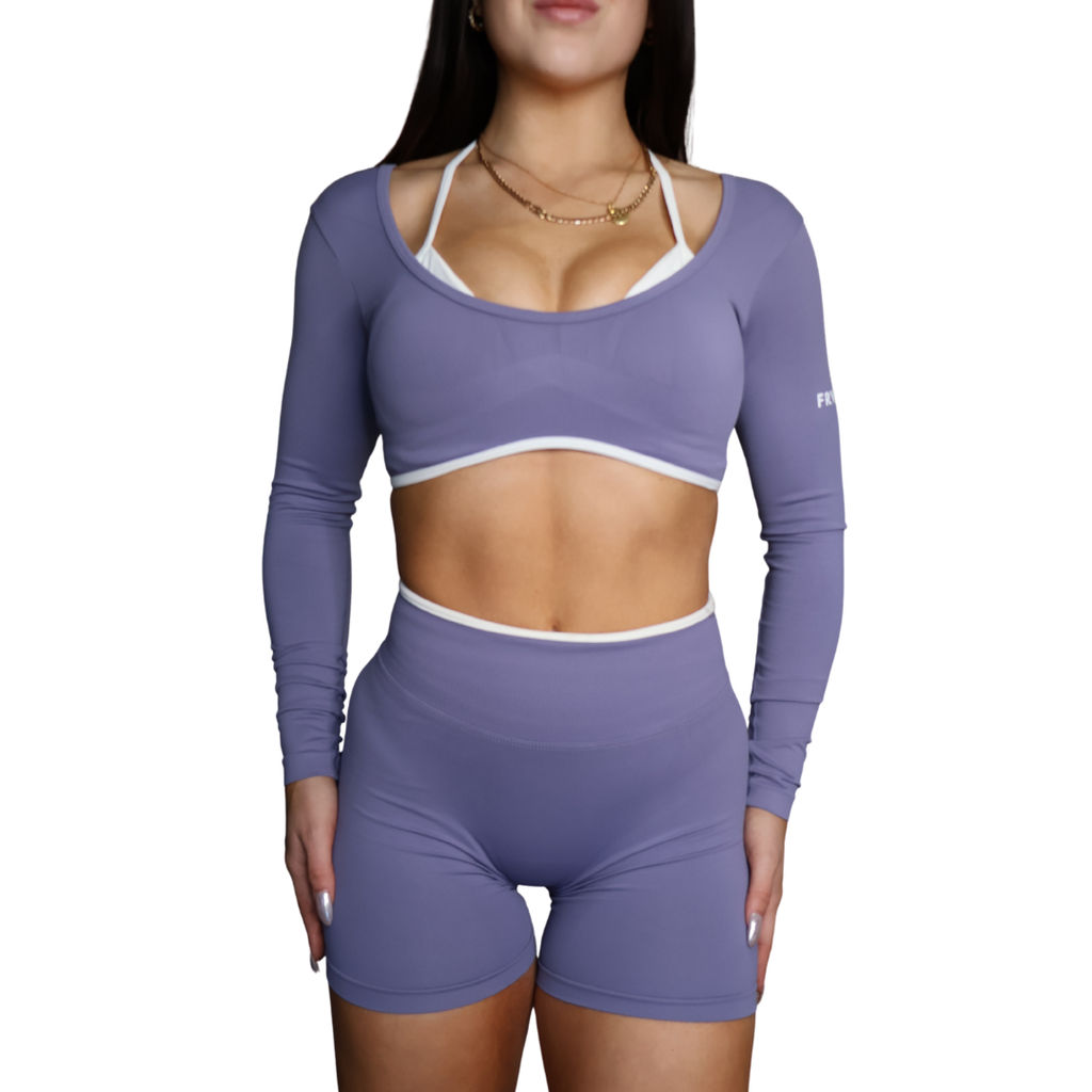 Woman wearing a long sleeve crop with built in halter neck sports bra.