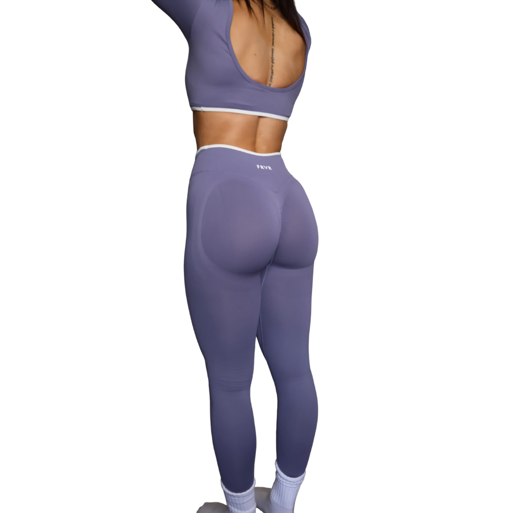 Girl wearing purple/blue grey seamless leggings with a scrunch detail. Glute lifting and sculpting leggings.